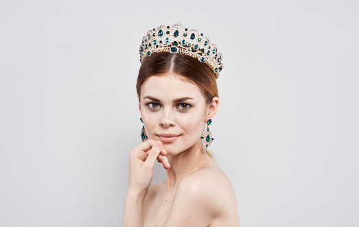 Beautiful woman with diadem on her head Princess queen model with earrings portrait. High quality photo