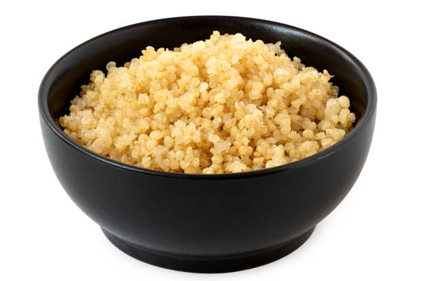 istock Cooked white quinoa in a black ceramic bowl isolated on white. 2111738652