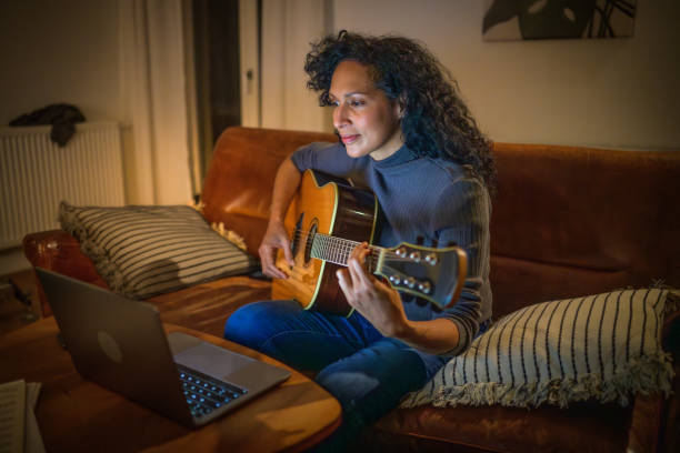 istock Woman learning to play guitar 2111742784