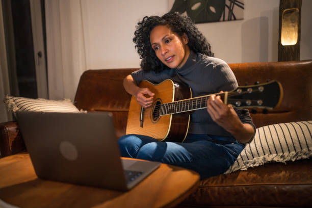 istock Woman learning to play guitar 2111749034