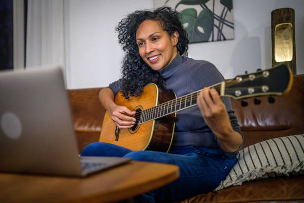 istock Woman learning to play guitar 2111750068