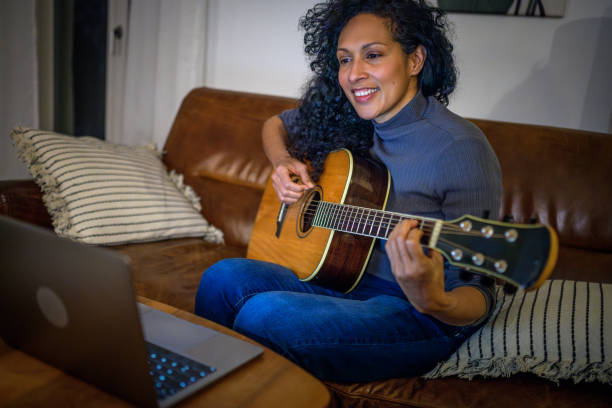 istock Woman learning to play guitar 2111751129