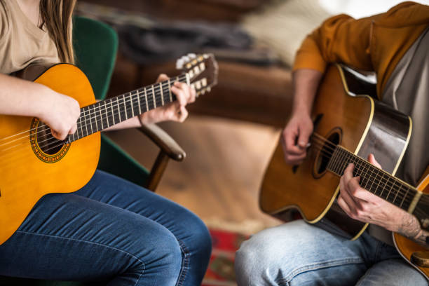 istock Girl and man playing guitar 2111754304