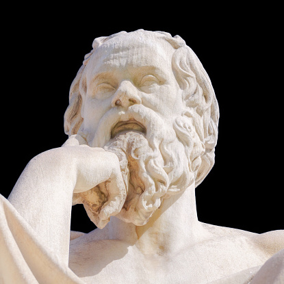 Close-up of a statue of the classical Greek philosopher Socrates, located at the Academy of Athens, isolated against a black background. The statue was completed in 1885 by Leonidas Drosis.