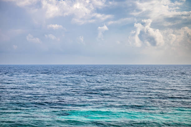 Calm ocean at the Malaccan Strait with just water, horizon and clouds at an idyllic beach outside the city of Sabang which in the main city on the island Weh north of Sumatra