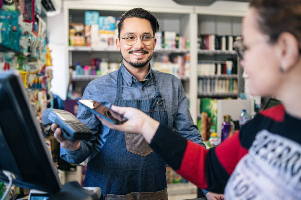 istock Customer paying  at supermarket using his smartphone 2111807985