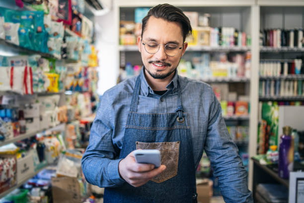 istock Owner at the supermarket  working and checking email on smartphone. 2111807991