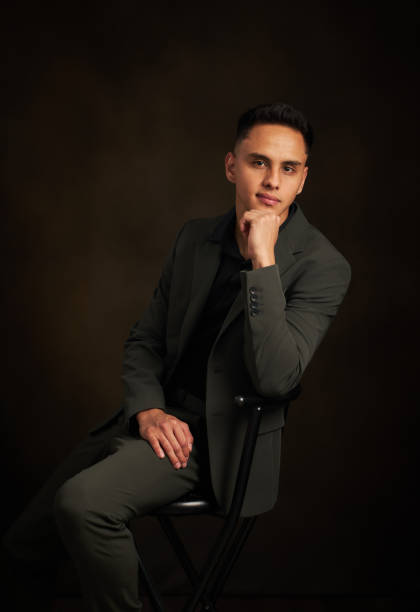 istock A man in a suit is sitting on a chair and looking at the camera 2111820332