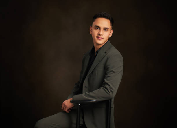 istock A man in a suit is sitting on a black chair 2111820334
