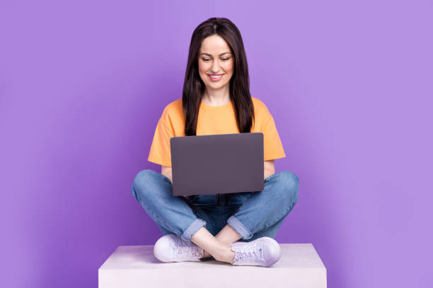 istock Photo of brunette hair senior level programmer woman sitting office podium write a code using laptop isolated on purple color background 2111844056