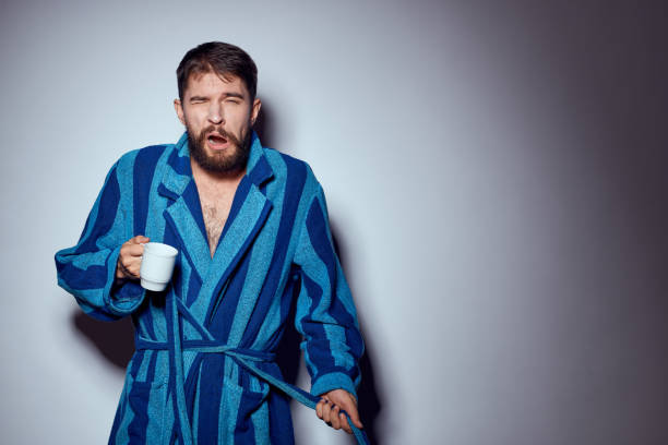 istock man in a blue robe with a white cup in his hand on a light background gesturing with his hands cropped view 2111847288
