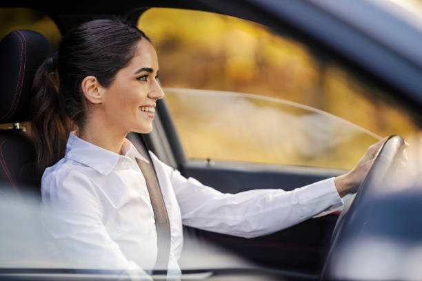 istock A happy female driver is driving car. 2111860550