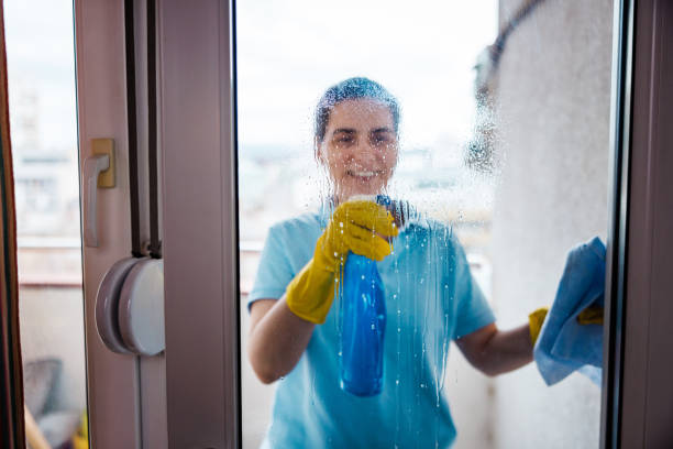 istock Smiling woman washing windows 2111874400