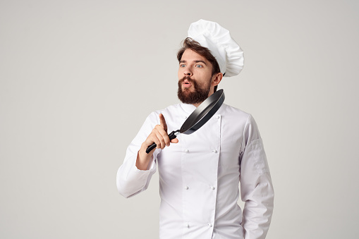 a man in a chef's uniform pan cooking kitchen isolated background. High quality photo
