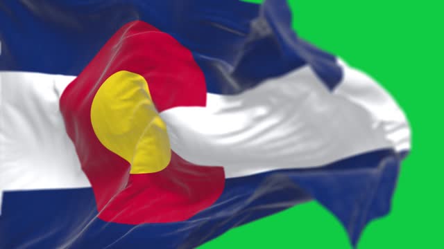Close-up of Colorado state flag waving isolated on green background