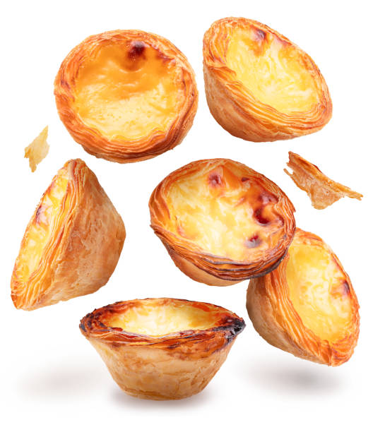 Pastel de nata tarts levitating in air on white background.