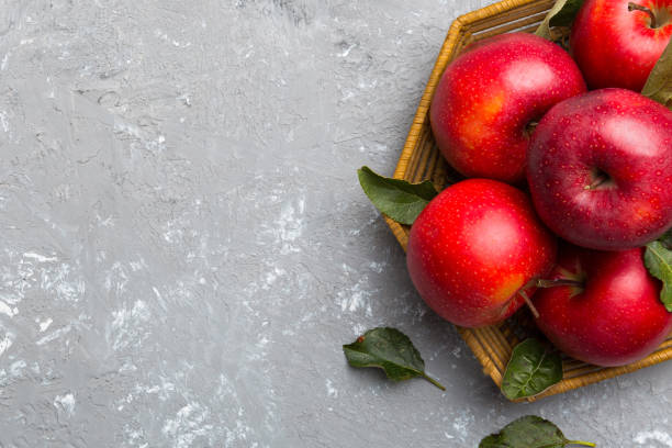 istock Many red apples on colored background, top view. Autumn pattern with fresh apple above view with copy space for design or text 2111894267