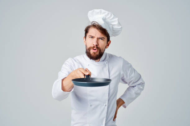 istock bearded man chef with a frying pan in hand isolated background 2111905443