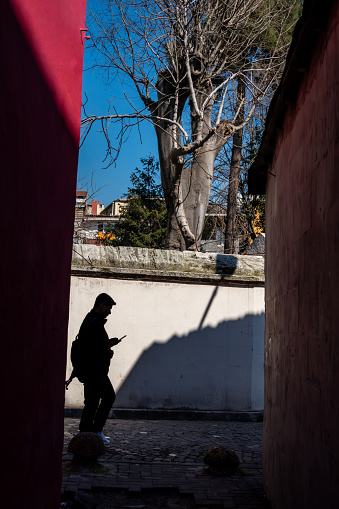 Istanbul, Turkey March 18, 2023. A man walks in silhouette in the Balat district.