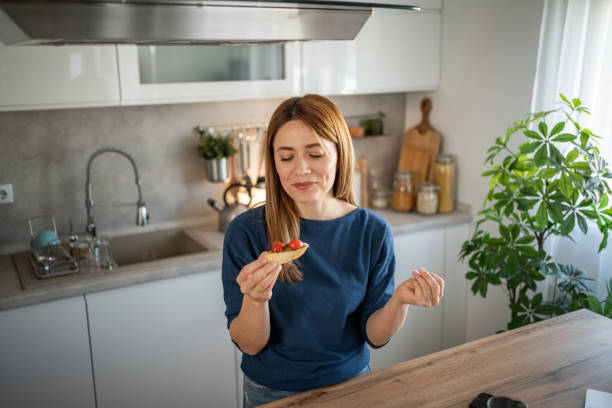 istock A young woman prepares breakfast in her kitchen 2111947695