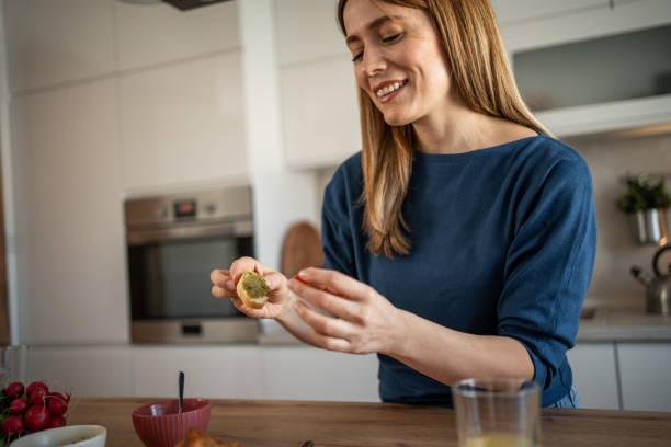 istock A young woman prepares breakfast in her kitchen 2111947769