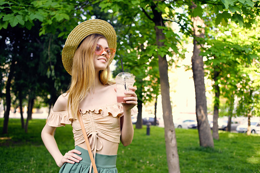cheerful woman in a hat in the park drink rest Lifestyle. High quality photo
