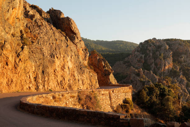 Huge and high rocky mountains along side of a road going to town of Corsica, France