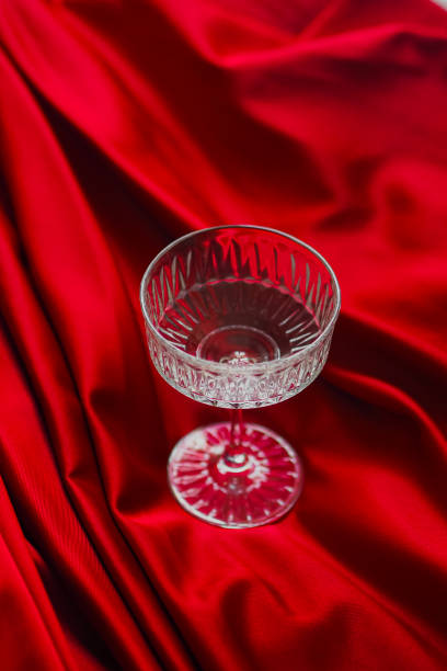 istock Vertical closeup of an empty glass on a red bedsheet 2112040086
