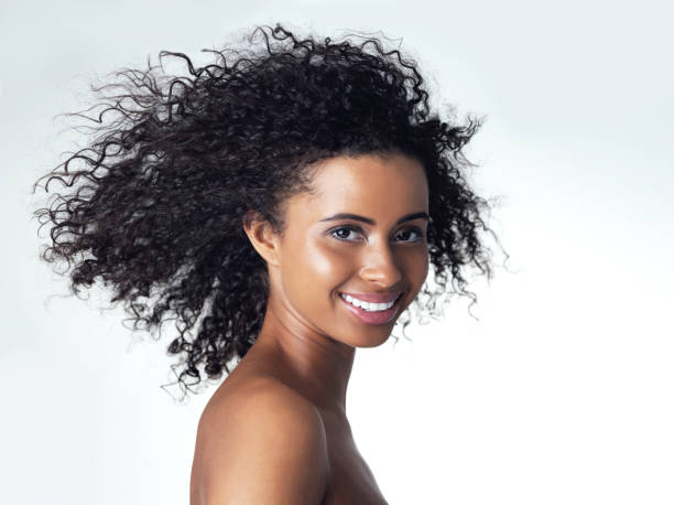 istock Studio portrait of a gorgeous young woman smiling while standing topless against a grey background 2112045140