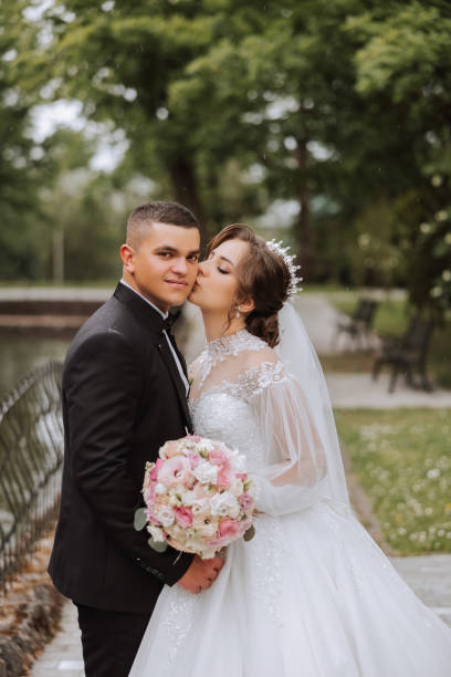 istock Wedding. Love and couple in garden for wedding. Celebrating the ceremony and commitment. Save the date. Trust. The groom embraces the bride. Tender kisses. Couple in love. Wedding portrait 2112052855