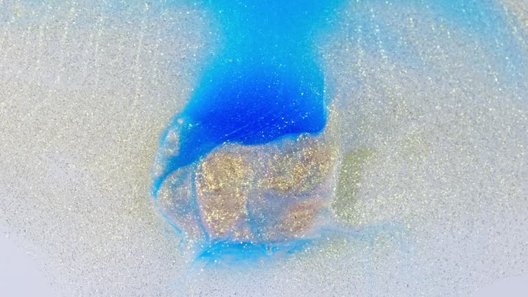 Blue and purple ink merging in water, creating an abstract cloud, top view, studio lighting