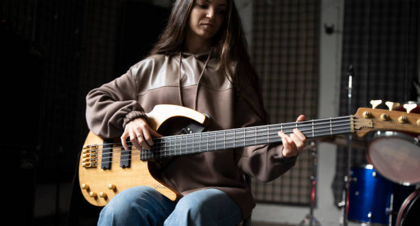 istock Young Musician Playing electric Guitar in a Studio Setting During a Rehearsal, playing accord 2112060574