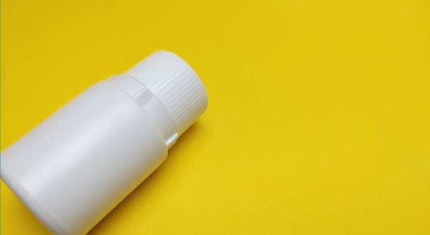 istock medicine bottle over yellow background 2112074086