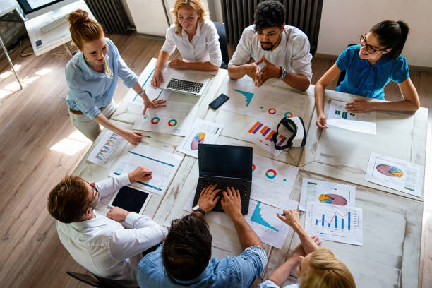 istock Group of multiethnic business people brainstorming, analyzing financial reports in office 2112084215