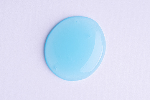 Transparent blue cosmetic sample texture with bubbles. Cosmetic peeling gel. Cosmetic blue peeling gel, beauty texture background