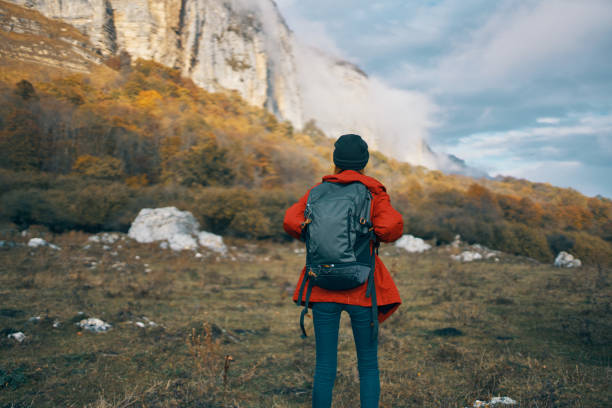 istock woman model In a red jacket with a backpack in the fall outdoors warm hat 2112107896