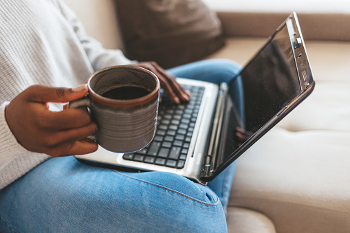 Closeup shot of an unrecognizable woman using a laptop while working from home.