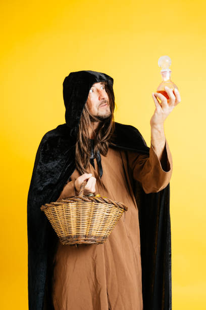 A person dressed as a druid with a basket looks at a potion, creating a mystical atmosphere.