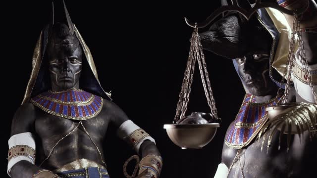 Anubis is sitting in a dark room and close up of Anubis with golden scales