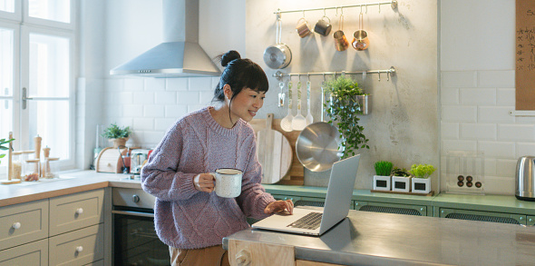 Photo of a Japanese woman using a laptop while working from her home.