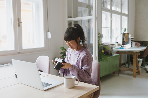 Photo of a Japanese woman using a laptop while working from her home.