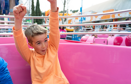 Child having fun on the cup attraction at an amusement park