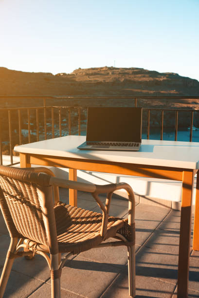 istock Laptop on the table on the balcony. Freelancing and remote work concept. 2112226293