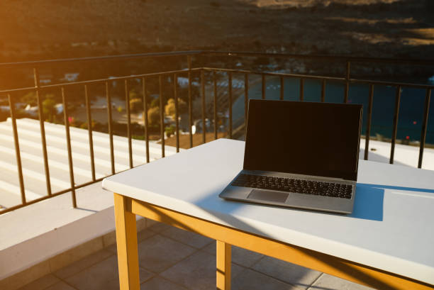 istock Laptop on the table on the balcony. Freelancing and remote work concept. 2112226298