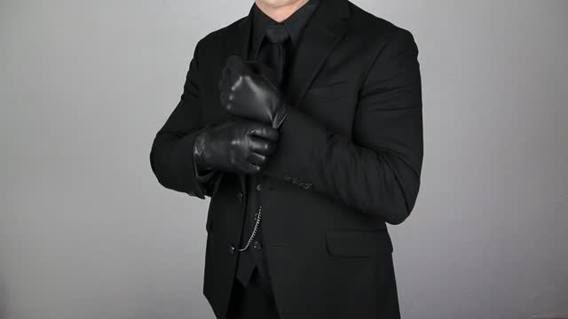 Mafia Hitman Pulling on Leather Gloves in Threatening Manner