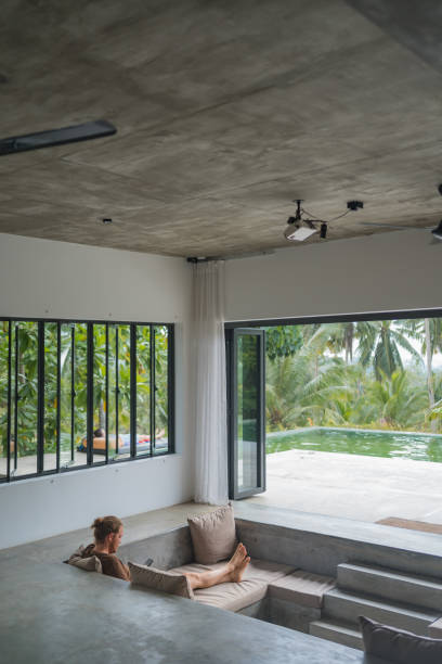 istock Young man reads book in open air living room 2112245496