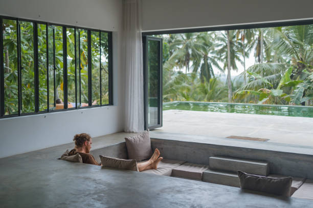 istock Young man reads book in open air living room 2112246033