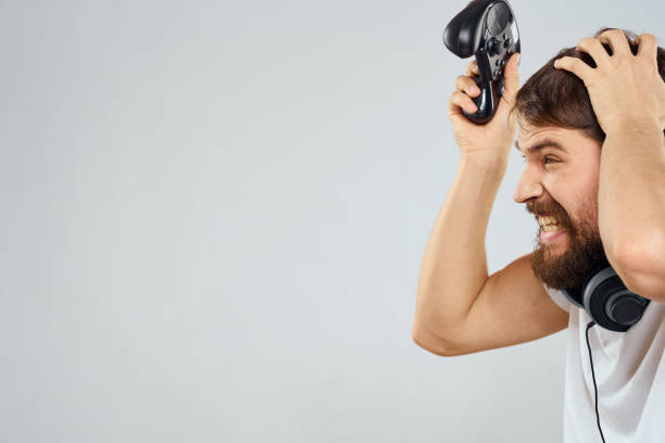 istock Man with gamepad headphones playing leisure technology white t-shirt light background 2112263338