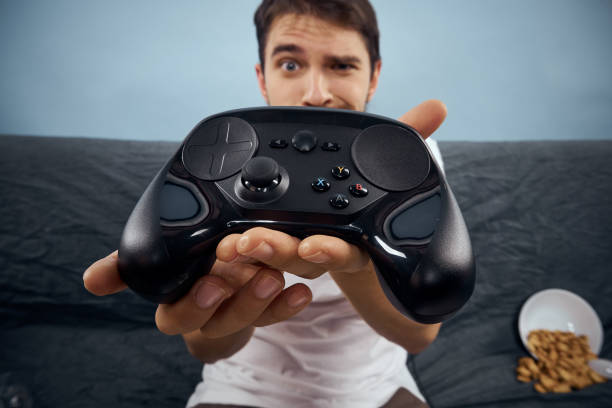 istock A man sits on a sofa with a gamepad in his hand. Leisure lifestyle game console 2112264421
