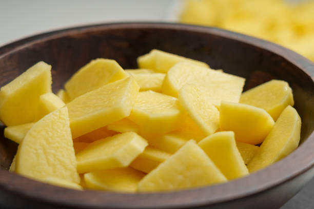 istock Raw sliced potatoes in a rustic wooden bowl 2112277133
